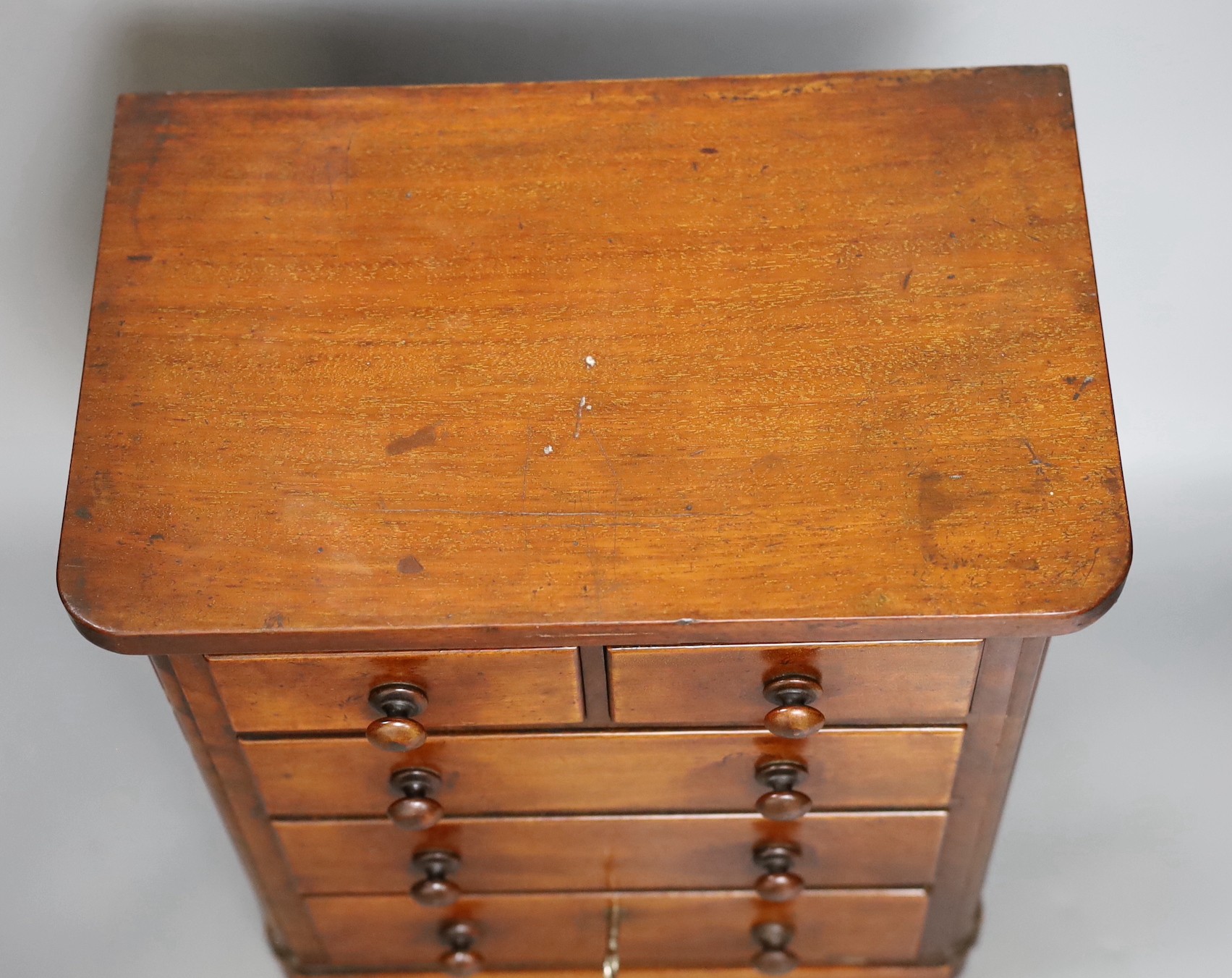 A Victorian miniature chest with five drawers and a key, 38cm tall